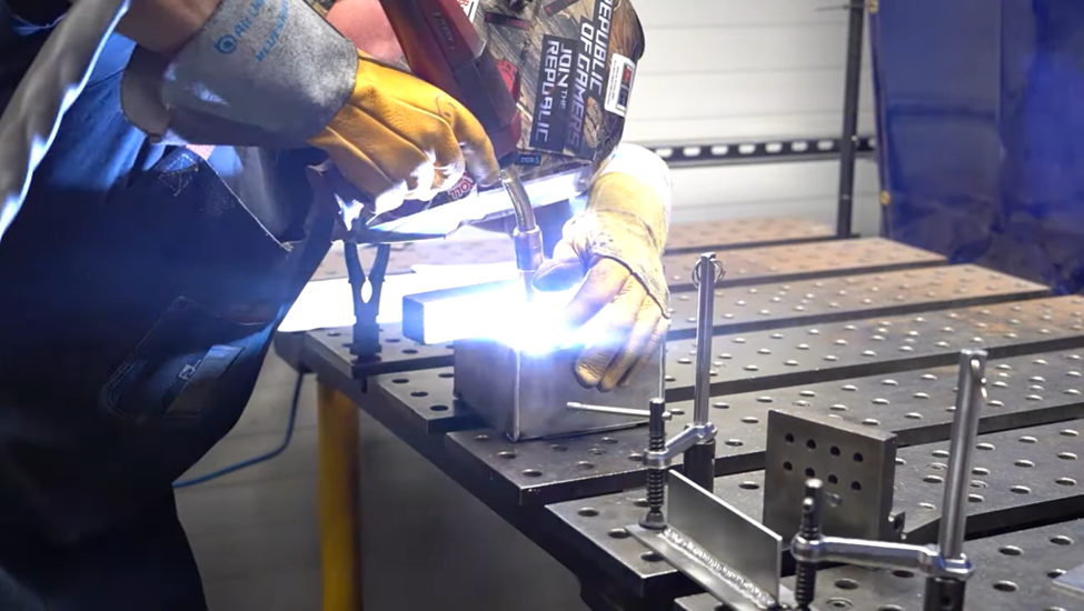 A welder performing plug welding - one of the ways to add strength to sheet metal parts