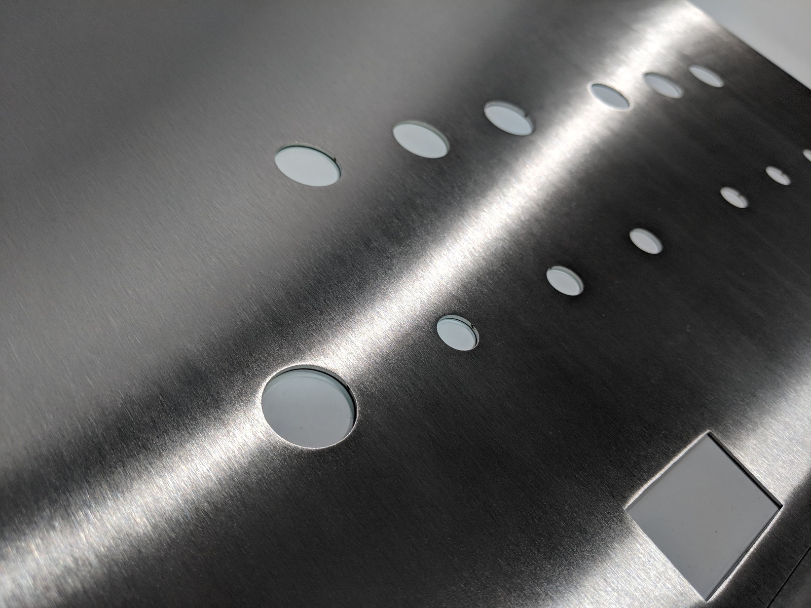 sheet metal part with grained finish and cutouts